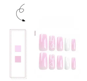 Detail of pink and white gradient press-on nails with heart patterns in medium square shape