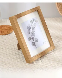 Detail of 5x7 inch light wood picture frame with back stand on textured background