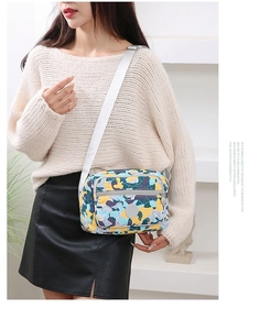 Crossbody bag detail showing colorful geometric pattern on model against white shelf