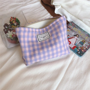 Close-up of pink and purple checkered canvas makeup bag with Time to Party woven label