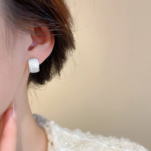 Elegant rectangular silver stud earrings with pearl texture on a model for a chic look
