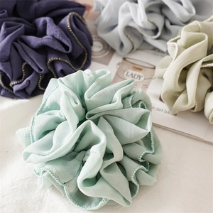 Close-up of pastel chiffon scrunchies with delicate bead trim and ruffled edges