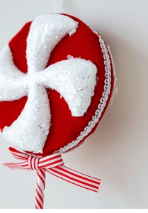 Close-up of red velvet Christmas candy ornament with white glitter and lace trim details