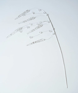 Macro detail of acrylic ice drop pendants and crystal beads on a silver decorative branch