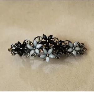 Macro detail of retro alloy hair clip with floral patterns and sparkling rhinestones