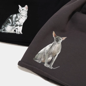 Gros plan sur la texture en tricot avec imprimés de chats réalistes sur bonnets gris et noirs