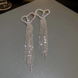 Macro view of crystal leaf tassel earrings with silver rhinestones and emerald green accents