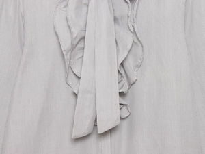 Detail of grey striped shirt collar with ruffles and adjustable tie-up bow