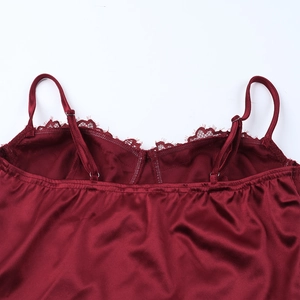 Close-up of burgundy satin dress showing delicate lace neckline and slim shoulder straps