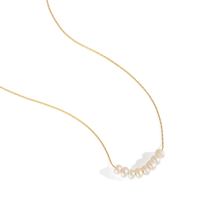 Detailed close-up of 8 white natural pearls on a thin gold waterproof chain necklace