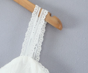Macro shot of fine lace shoulder strap detail with exquisite white floral embroidery