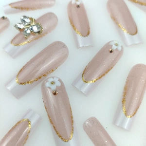 Faux ongles longs avec pointes françaises blanches, fleurs 3D et décoration papillon brillant