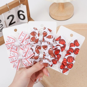 Detailed view of handmade sports themed bow hair clips with baseball and football prints