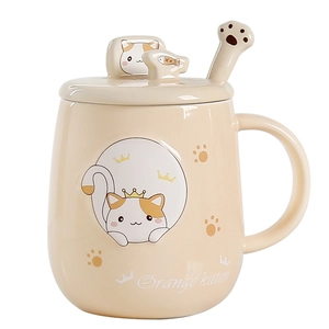 Ceramic orange kitten coffee mug with lid and cat paw spoon on white background