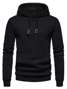Detail of black waffle knit texture on men's hoodie with adjustable drawstrings