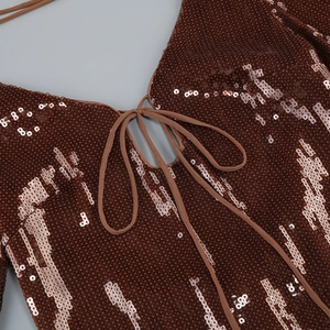 Detailed macro view of V-neck sequin dress with lace-up detail and sparkling fabric