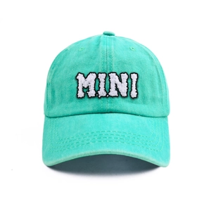 Detailed view of white MINI letter embroidery on a mint green cotton kids baseball cap