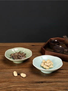 Close-up of ceramic petal-shaped snack plates with ice-cracked glaze for tea parties
