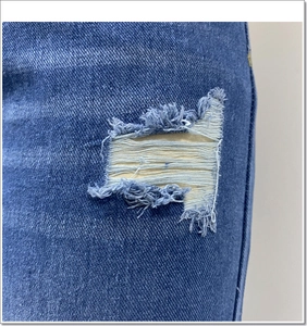 Detailopname van denim stof met gescheurde details en franjes aan de onderkant