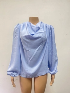 Detail view of the light blue chiffon blouse showing the draped neck and lantern sleeves