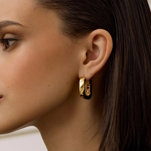 Thick gold rectangular hoop earrings in stainless steel on female model closeup