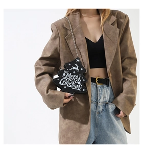 Close-up of Christmas tree shaped crossbody bag with reindeer print and metal chain strap