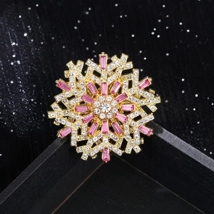 Exquisite gold snowflake brooch with pink and clear rhinestones on black background