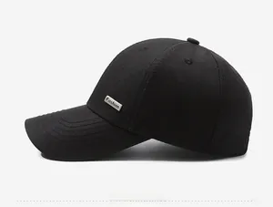 Detail of black baseball cap featuring a silver Fashion metal tag and stitched brim