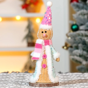 Detail of pink knitted Christmas gingerbread man with sequins on a wooden base