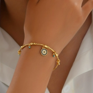 Fashionable golden Evil Eye cuff bracelet with blue stone detailing and adjustable open design