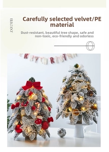 Close-up of mini flocked Christmas tree with LED lights and red ornaments for desk
