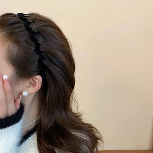 Detail view of black velvet wavy headband on model for an elegant vintage style