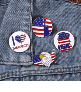 Detail of USA patriotic enamel pins on denim jacket featuring Statue of Liberty and Eagle