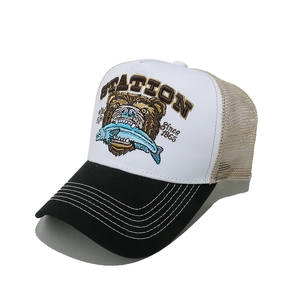Dettaglio del cappello trucker con ricamo di orso marrone e pannelli a rete traspirante