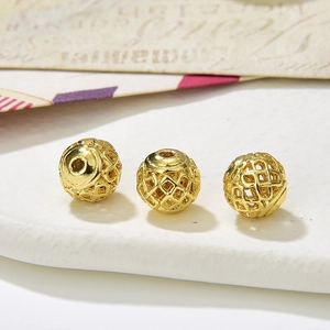Macro detail of golden hollow filigree ball beads for DIY jewelry making and crafts