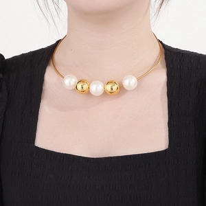 Elegant gold choker necklace featuring alternating pearls and metallic beads on a model