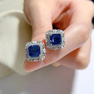 Macro shot of square royal blue stud earrings with double row halo of white crystals