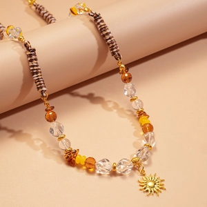 Gros plan du collier pendentif soleil avec perles ambrées et cordon ethnique tissé