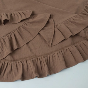 Vue macro détaillée des volants d'une robe marron avec coutures précises et texture naturelle