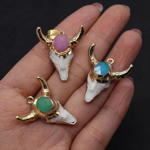 Three bull skull pendants in white resin with gold plating and colorful stone accents