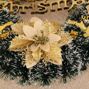 Close-up of Christmas wreath featuring a gold glitter poinsettia, golden berries and pine