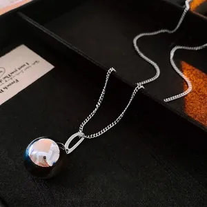 Polished stainless steel ball pendant necklace on a minimalist silver-tone cross chain