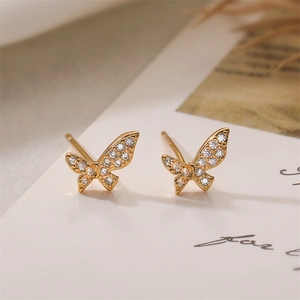 Macro shot of gold-plated butterfly stud earrings with sparkling crystal accents