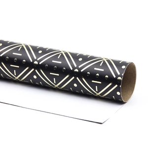 Roll of premium black gift wrapping paper with metallic gold geometric patterns