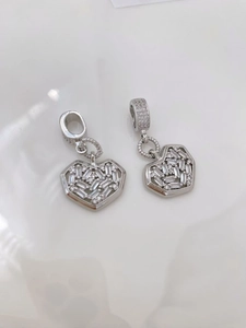 Detailed macro view of silver starburst heart pendants featuring hexagon frames and gems