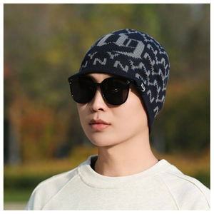 Close-up of a men's navy blue knitted beanie with plush lining and gray abstract pattern