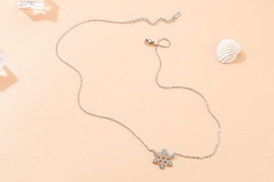 Detailed view of silver snowflake pendant necklace with lobster clasp and extender chain