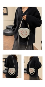 Dettaglio borsa a cuore in strass argento con motivo a freccia rossa e tracolla