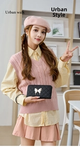 Detailed view of a black quilted long wallet with silver butterfly metal buckle