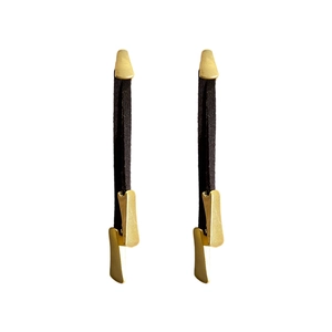 Elegant gold metal drop earrings with black leather fringe tassels on white background